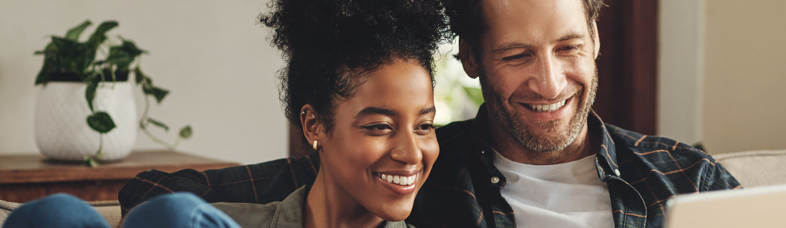 Photo of Couple smiling while looking at laptop