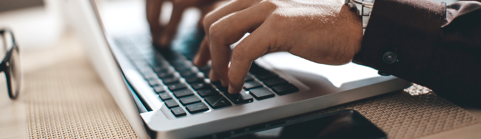 Photo of hands keying in information on laptop