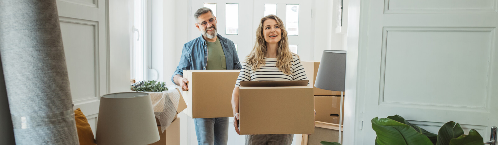 Two adults holding moving boxes