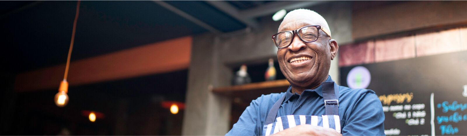 Older man in an apron smiling